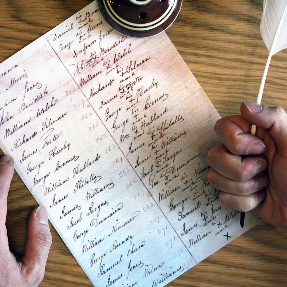 Paper with signatures and hand holding quill pen